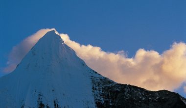央邁勇(藏語是文殊菩薩的意思)山，是四川亞丁的三神山之一。山背後似乎黏著了一團棉花糖式地反射著夕陽的金黃雲朵。(攝影／王志宏)
