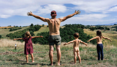 一名父親和他的三個小孩衣著簡便，在山丘上盡情伸展身軀。(攝影／Denis Meyer)