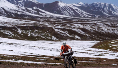澳洲選手正推車往這場絲路山地自行車賽中排名第三高的山峰卡拉科爾(Karakol)登山口。