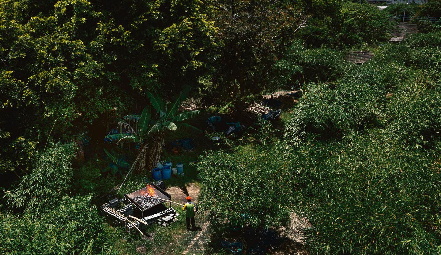 在雲林古坑鄉麻園村種植烏殼綠竹筍的竹農沈榮堂，正將放置了一年以上的竹廢料，放進造型特殊的「金字塔爐」進行焚燒。(攝影／劉子正)