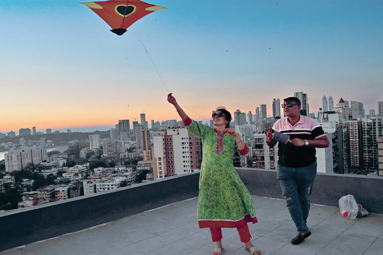 一般旅人看不透的孟買，處處充滿各種驚奇的異國色彩與神祕的魅力，比如這對夫妻在自家陽台上放風箏，是傳統風箏節後迎接豐收之神的祝禱。(圖片／Anshuman Poyrekar／達志影像)