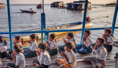 柬埔寨西北方洞里薩湖，是東南亞最大的內陸湖，水上浮村奧科爾的孩童在油桶上的教室進行開學前祈禱。(攝影／Tommy Trenchard／Panos Pictures)
